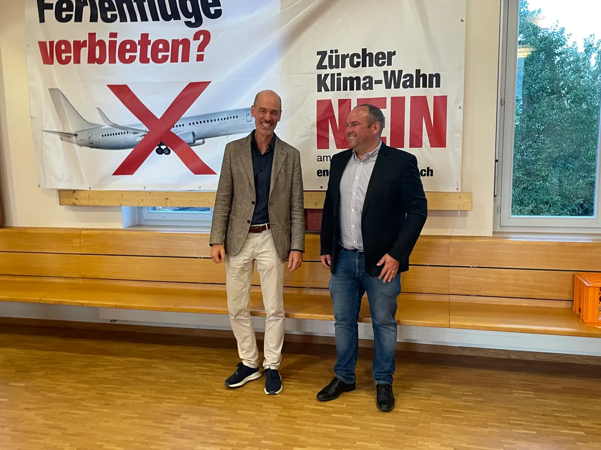Zwei Kantonsräte stehen vor einem Plakat der SVP-Kampagne.